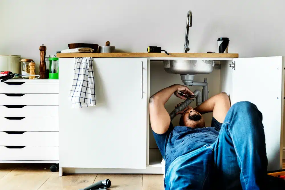 plumber man fixing kitchen sink drain cleaning