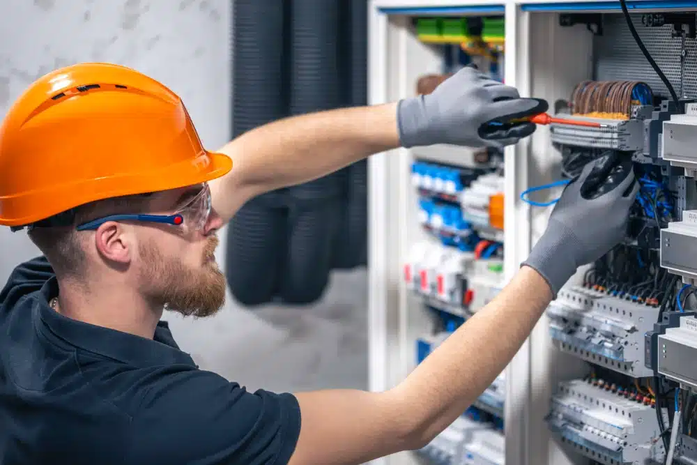 male electrician working switchboard with fuses electrical installation service